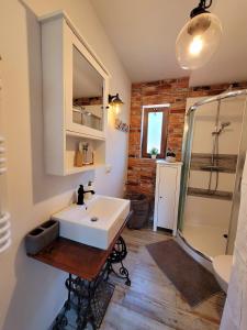 a bathroom with a white sink and a shower at Borsk Sielanka in Borsk