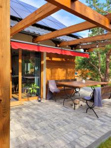 a picnic table and chairs on a patio with awning at Borsk Sielanka in Borsk