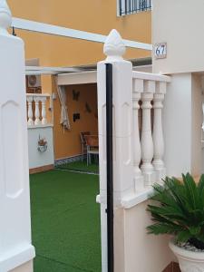 una casa con un prato verde nel cortile anteriore di Apartamento Terraza Arenales del Sol ad Arenales del Sol