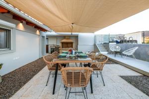 un patio con tavolo e sedie e una cucina di El Cielo Where Luxury meets the sky a Kalamáta