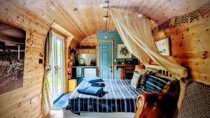 ein Schlafzimmer mit einem Bett in einer Holzhütte in der Unterkunft Emlyn's Coppice - Luxury Woodland Glamping in Holywell