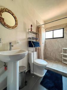 y baño con lavabo, aseo y espejo. en Condo Temis Vallarta, en Puerto Vallarta