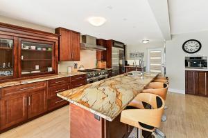 una cucina con armadi in legno e ripiano in marmo di Seven Mile View Condo #2 a West Bay