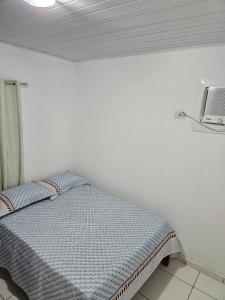 een bed in een witte kamer van 1 m2 bij Aconchegante casa perto da praia da Enseada dos Golfinhos OBS não é Jaguaribe in Jaguaribe