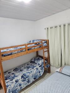 sypialnia z 2 łóżkami piętrowymi w pokoju w obiekcie Aconchegante casa perto da praia da Enseada dos Golfinhos OBS não é Jaguaribe w mieście Jaguaribe
