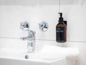 una botella de jabón en el lavabo del baño en Hotel Tower I 26th floor I Boxspring I Nespresso, en Augsburg