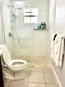 y baño con aseo y ducha con toallas. en Snug Harbour View Condo #4, en George Town