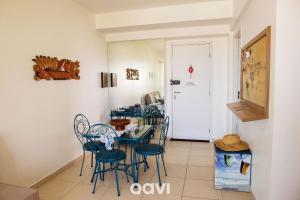 a dining room with blue chairs and a table at Qavi - Apartamento aconchegante no melhor de Ponta Negra #1603Áurea in Natal