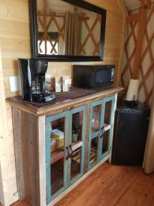 a wooden cabinet with a microwave on top of it at Cherokee @ Sky Ridge Yurts in Bryson City