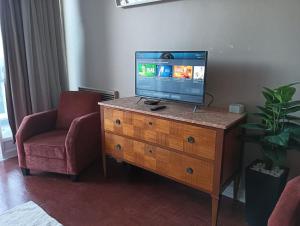 een televisie op een houten dressoir in een woonkamer bij Estoril big beach in Estoril