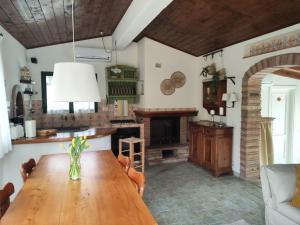 ガンバッシ・テルメにあるCasa Graziaのキッチン(木製テーブル、暖炉付)