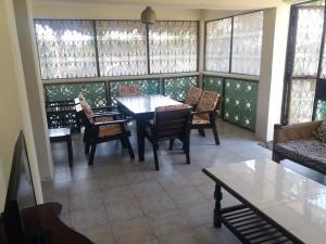comedor con mesa, sillas y ventanas en serene house to let in Diani en Kwale