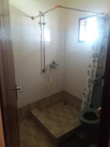 y baño con ducha, aseo y lavamanos. en serene house to let in Diani en Kwale