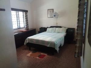 1 dormitorio con cama y ventana en serene house to let in Diani en Kwale