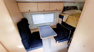una piccola camera con due sedie e un letto e una finestra di Camping-car a Vitry-le-François