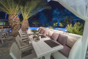 a living room with a couch and tables and palm trees at Zephyros in Paraga