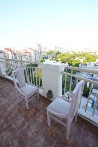 two chairs on a balcony with a view of a city at DESIRE Service Apartments- CyberCity in Gurgaon