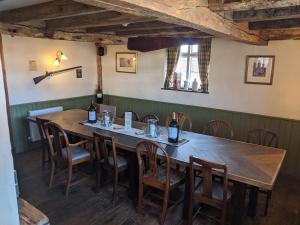 a dining room with a wooden table and chairs at The Crown Inn in Horsted Keynes