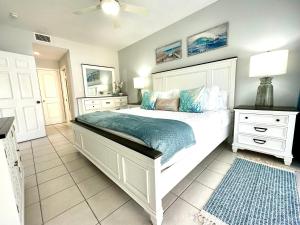 - une chambre avec un grand lit blanc et des oreillers bleus dans l'établissement Regal Beach Club #322, à George Town