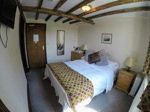 a bedroom with a bed and a wooden ceiling at The Crown Inn in Horsted Keynes