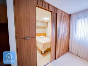 uma sala com uma porta que leva a um quarto em Apartamento de alto padrão no Caminho das Arvores em Salvador