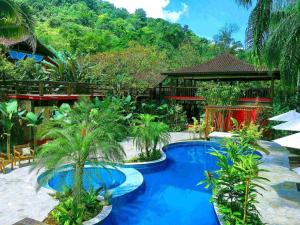 um resort com uma piscina azul em frente a um edifício em Villa Manakás em Camburi