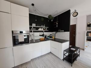 una cocina blanca con electrodomésticos en blanco y negro en Gryfny Grubiorz, en Katowice