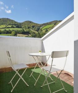 2 sillas y una mesa en un balcón con montañas en Leizarooms, en Leitza