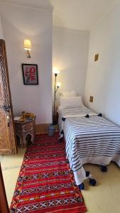 een slaapkamer met 2 bedden en een tapijt op de vloer bij Riad la Cigale in Marrakesh