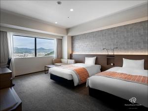 Daiwa Roynet Hotel Hiroshima-ekimae في هيروشيما: غرفة فندقية بسريرين ونافذة