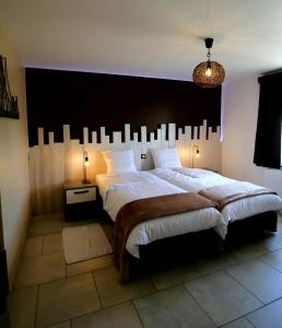 a bedroom with a large bed with a large headboard at Gite L'Abeille 