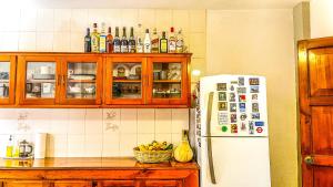 uma cozinha com um frigorífico branco e armários de madeira em Casa Nazimova Blue Room em San Cristóbal de Las Casas