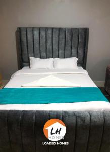 duże łóżko z czarno-niebieskim kocem w obiekcie Loaded homes w mieście Kikuyu