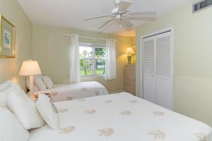 a bedroom with two beds and a ceiling fan at Cocoplum #5 Condo in George Town