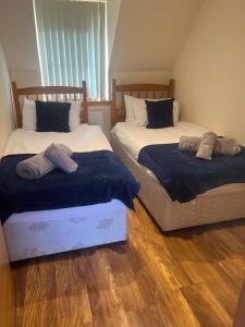 Dos camas una al lado de la otra en un dormitorio. en Druid Apartment, en Inverness