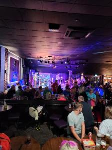 a group of people sitting at tables in a bar at Comfy caravan on marine park in Rhyl