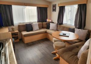 a living room with a couch and a table at Comfy caravan on marine park in Rhyl