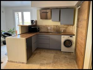 uma cozinha com um lavatório e uma máquina de lavar roupa em Chez ALYS - Appartement Sarlat em Sarlat-la-Canéda