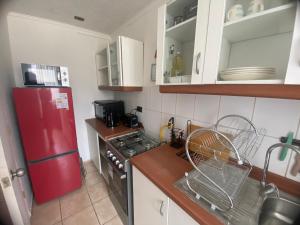 a kitchen with a red refrigerator and a stove at Apartamento altos del boldo in Curicó