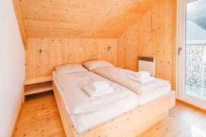 a bed in a wooden room with a large window at Chalet-Prinz-Murau-Kreischberg in Murau