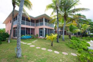 a pink house with palm trees in front of it at Northern Lights #6 Condo in Old Man Bay