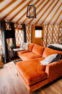 una yurta con sala de estar con sofá naranja en Santeetlah @ Sky Ridge Yurts, en Bryson City
