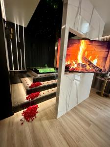 a fire pit in a room with flowers on the floor at Wiślane Tarasy VIP Apartamenty JACUZZI in Krakow