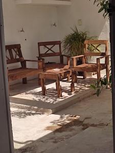 a group of wooden benches sitting on a patio at HOSPEDAJE MAGNOLIAS MERIDA in Mérida