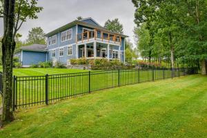 a blue house with a fence in front of a yard at Secluded Home with Hot Tub about 5 Mi to Cornell! in Ithaca