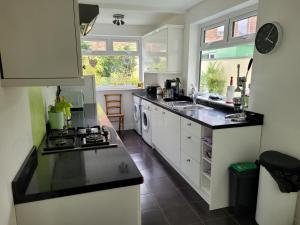 a kitchen with white cabinets and black counter tops at No 35 Guisborough - 2 bedroom house in Guisborough