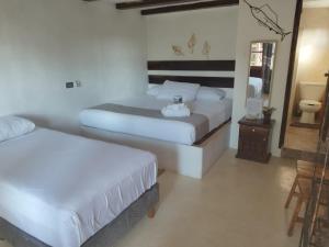 Habitación de hotel con 2 camas y espejo en Hotelito Crismi en Holbox Island