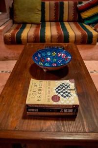 een houten salontafel met een boek en een kom erop bij Casabu in Zihuatanejo