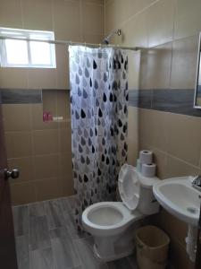 een badkamer met een toilet en een douchegordijn bij HOSPEDAJE MAGNOLIAS MERIDA in Mérida