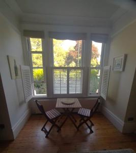 a room with a table and two chairs and windows at Charming luxury 1 bed apartment in London